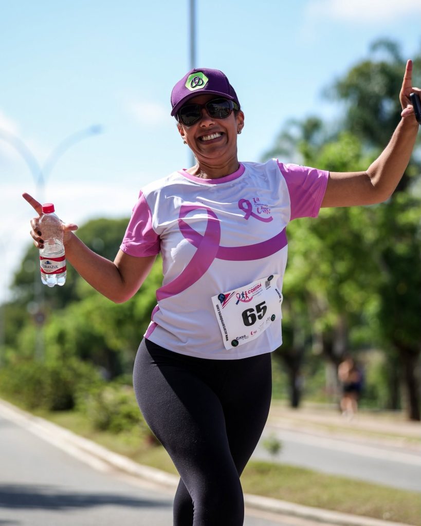 Participante comemora durante a Corrida e Caminhada Outubro Rosa e Novembro Azul